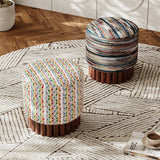 Two patterned stools on a wooden floor with a rug.