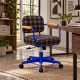 A modern office chair with a black and orange plaid upholstered seat and back, blue metal frame, and light wood armrests, shown in a bright home office setting next to a desk.