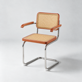 A cantilever dining chair with a warm brown wood frame, woven cane backrest and seat, and a polished chrome tubular steel base, photographed on a light gray studio background.