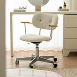 Ivory boucle office chair with wooden arm pads and a polished castor base in front of a white dressing table.