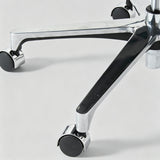 Close-up of a chrome office chair base with black casters on a light gray background.