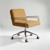 A modern office chair with a tan and brown plaid upholstered seat and back, chrome metal armrests and base, and black caster wheels, shown on a light gray studio background.