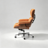 A modern lounge chair with orange-brown textured upholstery, a dark wood-grain base, and a chrome rolling mechanism, shown against a light gray studio background.