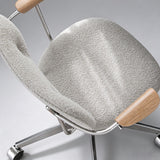Close-up from above of the office chair's light grey boucle seat cushion, matching backrest and wooden arm pads.
