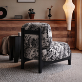 Rear view of the botanical accent chair showing its upholstered back cushion and tall black frame supports.

