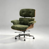 An iconic mid-century modern lounge chair with olive green velvet upholstery, a curved wooden shell, and a chrome five-star swivel base with casters, photographed on a seamless light gray studio background.