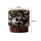 An upholstered cylindrical ottoman or stool with a multicolor woodland-style patterned fabric and a fluted dark wood pedestal base, shown on a white background with dimension arrows labeled 43CM width and 43CM height.