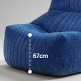 Close-up of a blue textured fabric chair or sofa cushion with a white dashed measurement overlay showing 67cm height on a light gray studio background.