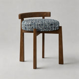 A wooden dining chair with a curved backrest and a round tufted seat cushion upholstered in a blue and white textured tweed fabric, shown against a neutral light gray background.