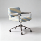 A modern armchair with a blue and beige striped bouclé fabric upholstery, chrome metal armrests and base, and black caster wheels, photographed on a light gray studio background.