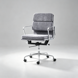 A modern office chair with a textured gray fabric upholstered seat and backrest, supported by a polished chrome five-star base with black casters, set against a neutral light gray studio background.