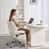 Person seated in a cream padded office chair with a chrome castor base, using a laptop at a white desk.
