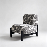 Ivory accent chair with black tiger motifs, rounded seat and back cushions, and a black frame.

