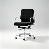 A modern office chair with black textured fabric upholstery and a polished chrome five-star base with casters, photographed on a seamless light gray studio background.