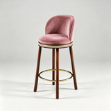 Dusty pink Alma bar stool with a padded round seat, curved backrest, dark wood legs and gold-tone footrest.
