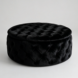 A round black velvet ottoman with a tufted diamond pattern and a matching lid, photographed on a clean light gray studio background.