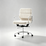 An office chair with cream-colored upholstered seat and back cushions, chrome metal armrests and base, and black casters, shown on a light gray studio background.