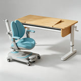 A children's ergonomic desk and matching adjustable chair set on a light gray studio background. The desk has a light natural wood top with a fold-down writing surface and white metal legs.