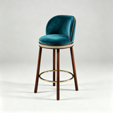 Teal Alma bar stool with a curved upholstered backrest, dark wood legs and a gold-tone circular footrest.
