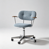 Light blue boucle office chair with a buttoned backrest, wooden arm pads and a polished castor base.