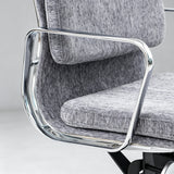 Close-up of a modern office chair with textured gray fabric upholstery and a polished chrome metal frame.