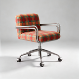 A modern office chair with a red, orange, and green plaid fabric upholstery and a polished chrome five-star base with casters, photographed on a light gray studio background.