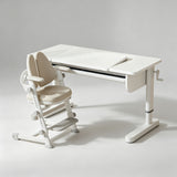 A white ergonomic desk with a matching adjustable child's height chair, shown on a clean light gray studio background.
