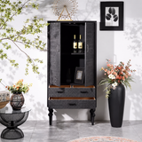 Black carved cabinet with doors and drawers open, revealing interior shelving, wine bottles and a framed photograph.