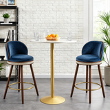 Two blue Alma bar stools with dark wood legs and gold-tone footrests beside a white round pedestal table.
