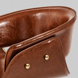 Close-up of the bar stool's brown leather outer backrest, showing stitched edges, a layered side panel and two gold-tone studs.

