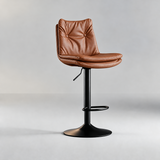 Cognac bar stool with a two-button tufted backrest, layered seat cushion and black pedestal base.