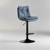 Muted blue-grey bar stool with a two-button tufted backrest, layered padded seat and black pedestal base.