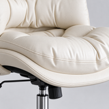 Close-up of the cream office chair's thick seat cushion, stitched front edge and curved upholstered seat support.
