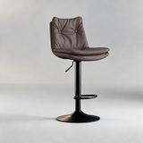 Dark mushroom taupe bar stool with a two-button tufted backrest, padded seat and black pedestal base.
