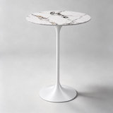 Round bar table with a white top, bold dark veining and a white pedestal base.