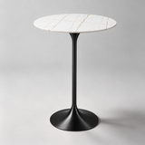 Round bar table with a white top, fine gold-toned veins and a black pedestal base.