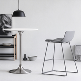 Round bar table with a white top and silver pedestal base, paired with a grey bar stool.
