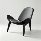 All-black lounge chair with padded seat and backrest, a curved wood shell with upswept sides and three splayed legs.
