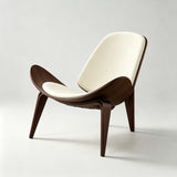 Lounge chair with cream padded seat and backrest, a dark brown wood shell with upswept sides and three splayed legs.

