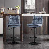 Two blue-grey button-tufted bar stools with black pedestal bases beside a modern home bar.